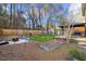 Large backyard featuring a wooden deck, fire pit, and garden beds, creating a perfect outdoor retreat at 409 Machost Dr, Garner, NC 27529