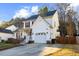 Well-maintained two-story home with red shutters, a charming front porch, attached garage, and paved driveway at 409 Machost Dr, Garner, NC 27529
