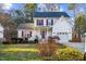 Classic two-story home with red shutters, a welcoming front porch, attached garage, and mature landscaping at 409 Machost Dr, Garner, NC 27529