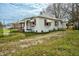 Back view of home featuring white siding, red and white awnings and a modest yard at 415 Estell St, Rocky Mount, NC 27803
