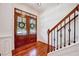 Elegant foyer with gleaming hardwood floors, a staircase with wrought iron railings, and a double-door entrance at 44 Grandwood Cir, Durham, NC 27712