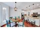 Cozy kitchen and breakfast nook featuring hardwood floors, white cabinets, and stainless steel appliances at 44 Grandwood Cir, Durham, NC 27712