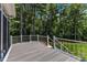 Wood deck with glass railings offers forest views and space for outdoor entertaining at 45 Calabria Ct, Clayton, NC 27527
