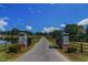 Long driveway leads to a grand estate, framed by an iron gate and manicured landscape at 45 Calabria Ct, Clayton, NC 27527