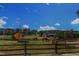 Idyllic horse property with two horses grazing in a green pasture with pond and wooden fencing at 45 Calabria Ct, Clayton, NC 27527