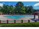 Large community swimming pool surrounded by a fence and lush trees offers a refreshing escape at 45 Calabria Ct, Clayton, NC 27527