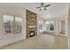 Bright sunroom features a stone fireplace, vaulted ceiling, and multiple windows for natural light at 45 Calabria Ct, Clayton, NC 27527