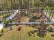 An aerial view reveals a private backyard oasis surrounded by lush landscaping and a white privacy fence at 49 Everwood Dr, Four Oaks, NC 27524
