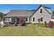 Large backyard features a well-manicured lawn, mature landscaping, and a covered patio perfect for entertaining at 49 Everwood Dr, Four Oaks, NC 27524