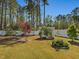 Well-manicured backyard featuring mature trees, lovely plantings and a white privacy fence at 49 Everwood Dr, Four Oaks, NC 27524