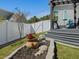 Charming backyard features a privacy fence, stone-lined garden bed, and a pergola-covered patio at 49 Everwood Dr, Four Oaks, NC 27524
