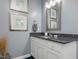 Bathroom vanity with granite countertops, framed mirror, and neutral wall color at 49 Everwood Dr, Four Oaks, NC 27524