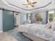 Spacious bedroom with blue accent wall and sliding barn door at 49 Everwood Dr, Four Oaks, NC 27524