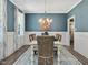 Elegant dining room featuring a white table, stylish chairs, and beautiful blue accent wall at 49 Everwood Dr, Four Oaks, NC 27524