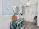 Well-decorated foyer with a light blue console table, round mirror, and elegant lighting fixtures at 49 Everwood Dr, Four Oaks, NC 27524