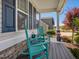 Relaxing front porch with charming rocking chairs, a small table, and decorative plants in colorful pots at 49 Everwood Dr, Four Oaks, NC 27524