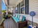 Comfortable front porch with a cozy wicker couch, decorative pillows, and stylish outdoor decor at 49 Everwood Dr, Four Oaks, NC 27524
