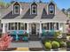Inviting front porch with blue furniture, decorative plants, and a welcoming entrance at 49 Everwood Dr, Four Oaks, NC 27524