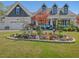 A beautiful two-story home with a colorful flower bed and three car garage at 49 Everwood Dr, Four Oaks, NC 27524