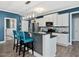 Kitchen island with counter seating, modern lighting, and stylish white cabinetry at 49 Everwood Dr, Four Oaks, NC 27524