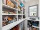 Open pantry with abundant shelving, storage, and light blue floral wallpaper at 49 Everwood Dr, Four Oaks, NC 27524