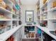 Spacious pantry with white shelving, floral wallpaper, and plenty of storage at 49 Everwood Dr, Four Oaks, NC 27524