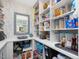 Pantry featuring white shelving, storage space, light blue floral wallpaper, and a window at 49 Everwood Dr, Four Oaks, NC 27524