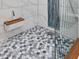 Walk in shower showcases unique mosaic tile flooring, white wall tiles, and glass enclosure at 49 Everwood Dr, Four Oaks, NC 27524