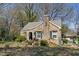 Charming stone cottage with green shutters and a unique architectural design, surrounded by lush greenery at 4914 Western Blvd, Raleigh, NC 27606