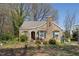 Charming stone cottage with green shutters and a unique architectural design, surrounded by lush greenery at 4914 Western Blvd, Raleigh, NC 27606