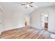 Bright bedroom featuring hardwood floors, a ceiling fan, and access to a bathroom and hallway at 500 W Woodcroft Pkwy, Durham, NC 27713