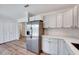 Stylish kitchen with white cabinets, stainless steel refrigerator, and wood flooring at 500 W Woodcroft Pkwy, Durham, NC 27713