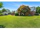 Expansive backyard featuring lush green grass, mature trees, and a detached garage with a well-maintained lawn at 504 W Brocklyn St, Benson, NC 27504