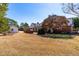 Spacious backyard with a brick patio, mature trees, and partial view of the house exterior at 504 W Brocklyn St, Benson, NC 27504