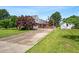 Long driveway leading to a well-maintained home with a basketball hoop, mature trees, and green grass at 504 W Brocklyn St, Benson, NC 27504