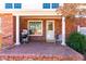Welcoming front porch with brick accents, a cozy chair, and a view of the charming front yard at 504 W Brocklyn St, Benson, NC 27504