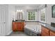 Bright bathroom featuring a soaking tub with tile surround and a wood vanity with dark granite countertops at 506 Rose Point Dr, Cary, NC 27518