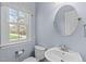 Powder room with a single sink vanity, toilet, and window allowing for plenty of natural light at 506 Rose Point Dr, Cary, NC 27518