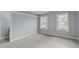 Spacious bedroom with neutral carpeting, fresh paint, and ample natural light from two windows at 506 Rose Point Dr, Cary, NC 27518