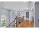Hallway with hardwood floors, light blue walls, wrought iron railing, staircase, and a chandelier at 506 Rose Point Dr, Cary, NC 27518