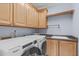Laundry room with washer, dryer, sink, granite countertops, and storage cabinets at 506 Rose Point Dr, Cary, NC 27518