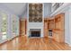 Cozy living room featuring hardwood floors, a fireplace, built-in shelving, and glass doors to the backyard at 506 Rose Point Dr, Cary, NC 27518