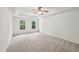 Spacious bedroom with tray ceiling, fan, neutral carpet, and two windows providing natural light at 5144 Pinehall Wynd, Raleigh, NC 27604