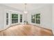 Bright dining room with hardwood floors, large windows, and an elegant crystal chandelier at 5144 Pinehall Wynd, Raleigh, NC 27604