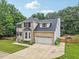 Aerial view of brick home featuring well-kept lawn and two-car garage at 5144 Pinehall Wynd, Raleigh, NC 27604