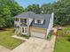 Aerial view of brick home featuring well-kept lawn and two-car garage at 5144 Pinehall Wynd, Raleigh, NC 27604