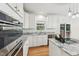 Updated kitchen showcasing granite countertops, white cabinetry, and modern appliances at 5144 Pinehall Wynd, Raleigh, NC 27604