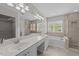 Bathroom featuring double sinks, soaking tub and tiled shower at 5301 Tilford Ln, Raleigh, NC 27613