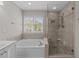 Bright bathroom featuring a soaking tub and glass-enclosed shower at 5301 Tilford Ln, Raleigh, NC 27613