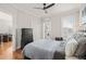 Comfortable bedroom with hardwood floors, ceiling fan, and convenient access to a laundry area at 605 Smedes Pl # A, Raleigh, NC 27605